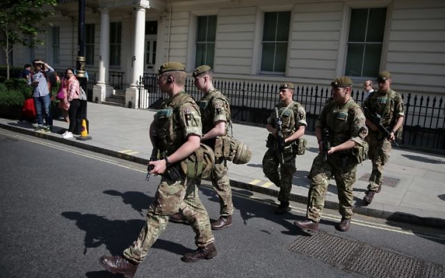 British Army soldiers are led by a police officer into Buckingham Palace in central London on May 24, 2017. (AFP PHOTO / Daniel LEAL-OLIVAS) British Army soldiers are led by a police officer into Buckingham Palace in central London on May 24, 2017. (AFP PHOTO / Daniel LEAL-OLIVAS)