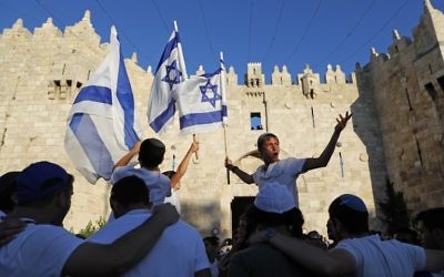Israelis wave the Israeli flag as they parade in front of Damascus Gate in Jerusalem's Old City on May 24, 2017 to commemorate Jerusalem Day, marking the reunification of the city following the 1967 Six Day War. (AFP/Thomas Coex)