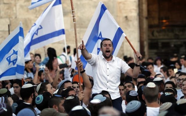 Israelis wave Israeli flags as they parade around Jerusalem's Old City on May 24, 2017 to commemorate Jerusalem Day, marking the reunification of the city following the Six-Day War of 1967. (AFP PHOTO / Menahem KAHANA)