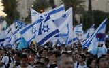 Illustrative: Israelis wave Israeli flags as they parade around Jerusalem's Old City on May 24, 2017, to commemorate Jerusalem Day, marking the reunification of the city following the Six Day War of 1967. (AFP PHOTO / Menahem KAHANA)