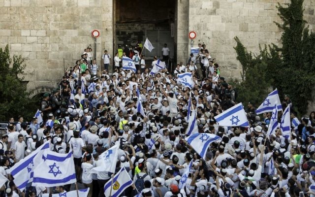 Israelis wave the Israeli flag as they parade through Damascus Gate in Jerusalem's Old City on May 24, 2017 to commemorate Jerusalem Day, marking the reunification of the city following the Six-Day War of 1967. (AFP PHOTO / Thomas COEX)