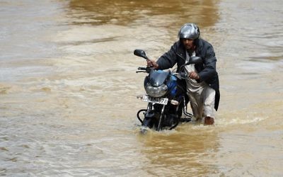 A Sri Lankan commuter pushes his motorbike through floodwaters on an expressway in the suburb of Athurugeriya in the capital Colombo on May 26, 2017. (Ishara S. Kodikara/AFP)