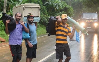 Sri Lankan villagers carry their belongings from their destroyed homes in Bellana village in Kalutara on May 26, 2017. (Lakruwan Wanniarachchi/AFP)