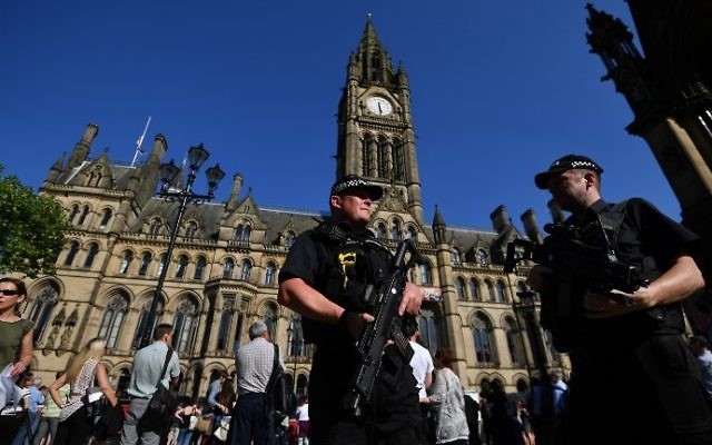 Armed police stand guard in front of the Town Hall in Albert Square during the GreatCity Games in central Manchester, England, on May 26, 2017. (AFP Photo/Ben Stansall)
