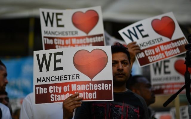 People hold up solidarity placards during a vigil in St Ann's Square in central Manchester, northwest England on May 26, 2017, following the May 22 terror attack at the Manchester Arena.( AFP PHOTO / Ben STANSALL)