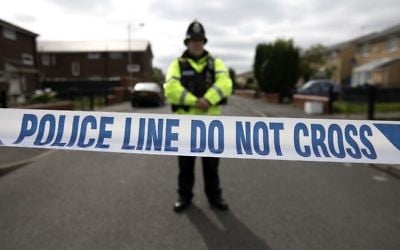 Illustrative: A police officer guards the entrance to a street in the Moss Side area of Manchester on May 28, 2017 during an operation. (AFP/John Super)