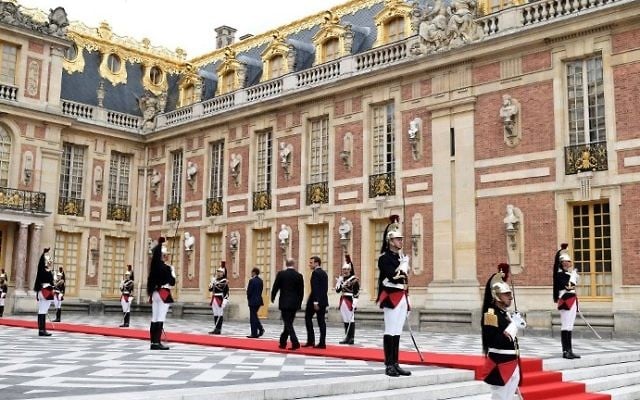 Russian President Vladimir Putin (L) is welcomed by French President Emmanuel Macron wave upon his arrival at the Versailles Palace, near Paris, on May 29, 2017, ahead of their meeting. (AFP PHOTO / STEPHANE DE SAKUTIN)
