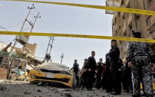 Iraqis gather at the site of a car bomb explosion near Baghdad's Al-Shuhada Bridge on May 30, 2017. (AFP/Sabah Arar)