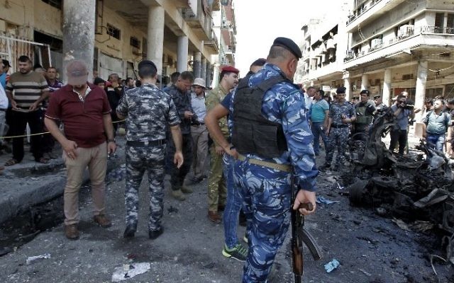 Iraqis gather at the site of a car bomb explosion near Baghdad's Al-Shuhada Bridge on May 30, 2017. (AFP PHOTO / SABAH ARAR)