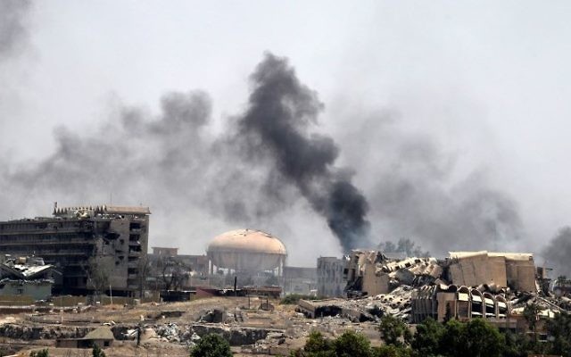 Smoke billows in a neighborhood of west Mosul's near Al-Shifa hospital (L) on May 30, 2017 during ongoing battles between Iraqi forces to retake the city from Islamic State (IS) group fighters. (AFP PHOTO / KARIM SAHIB)