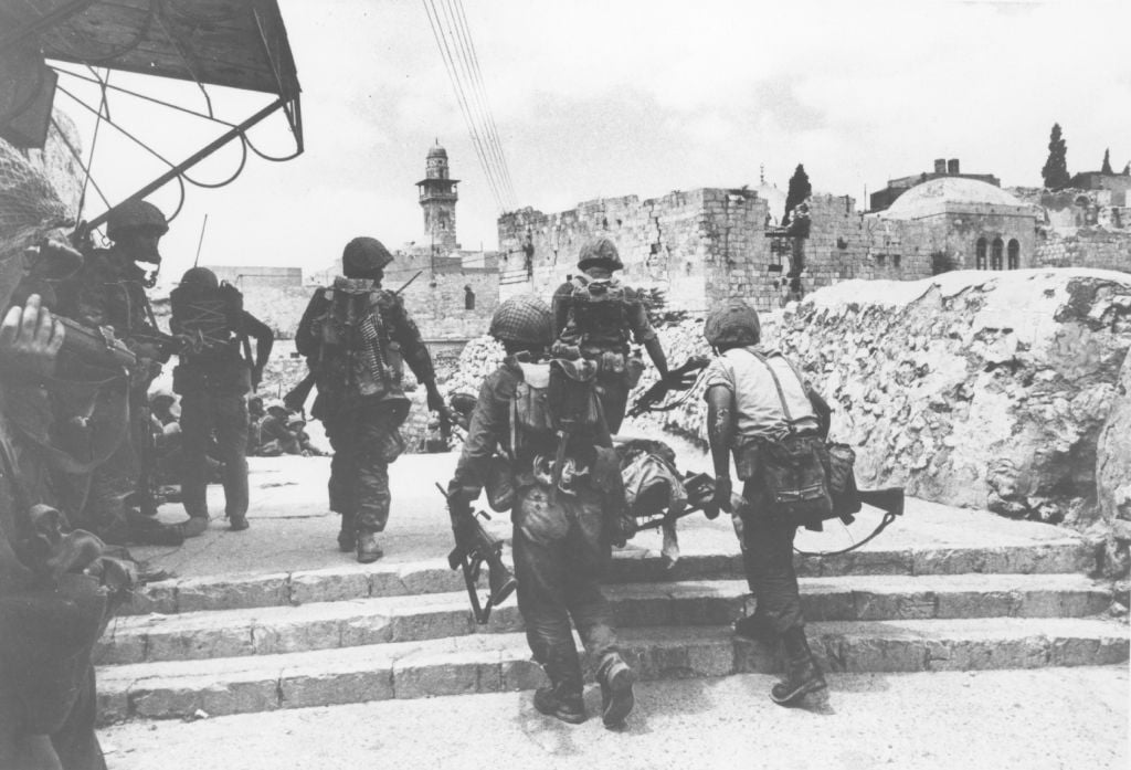Soldiers carry away an injured comrade on a stretcher through the streets of the Old City of Jerusalem on June 7, 1967. (Defense Ministry's IDF Archive) Soldiers carry away an injured comrade on a stretcher through the streets of the Old City of Jerusalem on June 7, 1967. (Defense Ministry's IDF Archive)