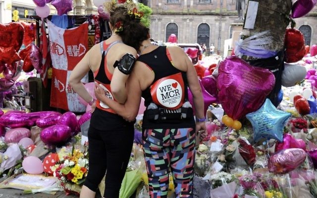Marathon runners pay respect at flower tributes in St Ann's square, before the Great Manchester Run in Manchester, England, May 28, 2017. (AP/Rui Vieira) 