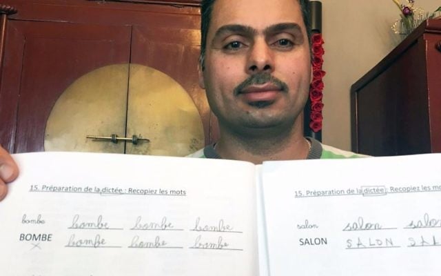 Iraqi refugee Raad Al Azzawi shows a lesson book at the house of his Belgian French tutor in Anderlecht, Belgium on Thursday, May 11, 2017. (AP Photo/Sylvain Plazy) Iraqi refugee Raad Al Azzawi shows a lesson book at the house of his Belgian French tutor in Anderlecht, Belgium on Thursday, May 11, 2017. (AP Photo/Sylvain Plazy)