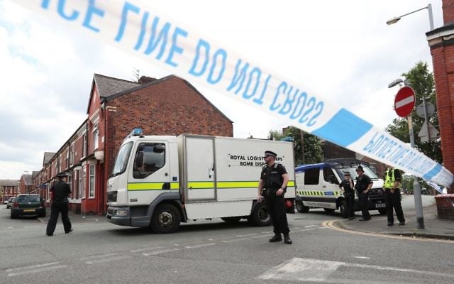 Police and a bomb disposal unit at the junction between Boscombe Street and Yew Tree Road, after an evacuation took place in the Moss Side area of Manchester, England, May 27, 2017. (Jonathan Brady/PA via AP)