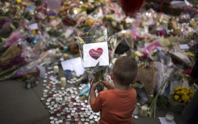 A child places flowers at a memorial site for the victims of the suicide attack at an Ariana Grande concert, set up in a square in central Manchester, Britain, May 24, 2017. (AP Photo/Emilio Morenatti) A child places flowers at a memorial site for the victims of the suicide attack at an Ariana Grande concert, set up in a square in central Manchester, Britain, May 24, 2017. (AP Photo/Emilio Morenatti)