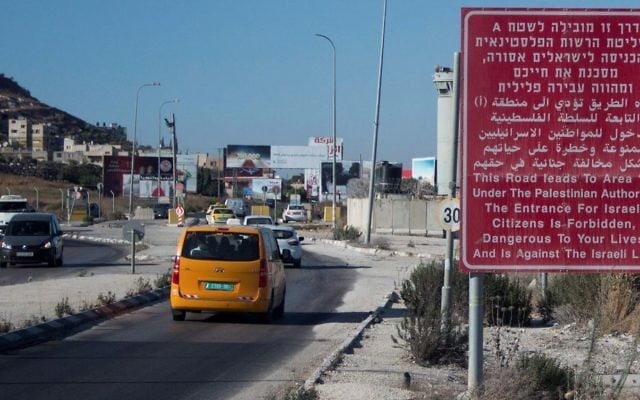 A red sign on the side of a road warns Israeli citizens against entering the West Bank city of Nablus on July 29, 2015. (Garrett Mills/Flash90) A red sign on the side of a road warns Israeli citizens against entering the West Bank city of Nablus on July 29, 2015. (Garrett Mills/Flash90)