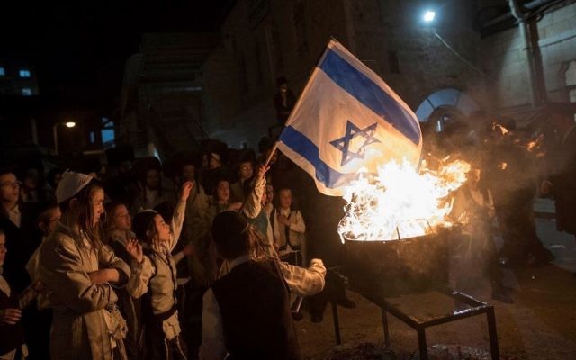 Ultra-Orthodox Jews burn an Israeli flag during Lag B'Omer celebrations in the ultra-Orthodox neighborhood of Mea She'arim in Jerusalem, on May 13, 2017. (Noam Revkin Fenton/Flash90) Ultra-Orthodox Jews burn an Israeli flag during Lag B'Omer celebrations in the ultra-Orthodox neighborhood of Mea She'arim in Jerusalem, on May 13, 2017. (Noam Revkin Fenton/Flash90)