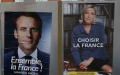 Election campaign posters for French centrist presidential candidate Emmanuel Macron and far-right candidate Marine Le Pen are displayed in front of the polling station where Marine Le Pen will vote in Henin Beaumont, northern France, Saturday, May 6, 2017. (AP Photo/Francois Mori)