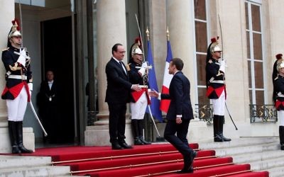 Outgoing French president Francois Hollande, left, greets President Emmanuel Macron before the handover ceremony, at the Elysee Palace in Paris, France, Sunday, May 14, 2017. (AP Photo/Christophe Ena)
