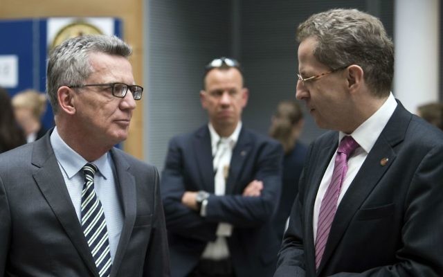 German Interior Minister Thomas de Maiziere, left, listens to German domestic intelligence chief Hans-Georg Maassen during a symposium in Berlin, Germany, Monday May 29, 2017. (Bernd von Jutrczenka/dpa via AP)
