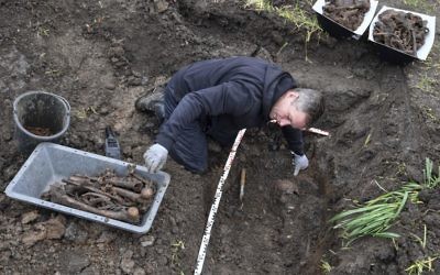 Joachim Kozlowski from the Volksbund charity that takes care of war graves, works at a mass grave in the town of Seelow 70 kilometers (43 miles) east of Berlin, Germany, Monday, May 8, 2017. (Patrick Pleul/dpa via AP)