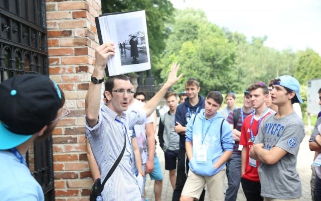 JRoots educator Zak Jeffay leading a tour in the Warsaw Jewish Cemetery. (Courtesy)