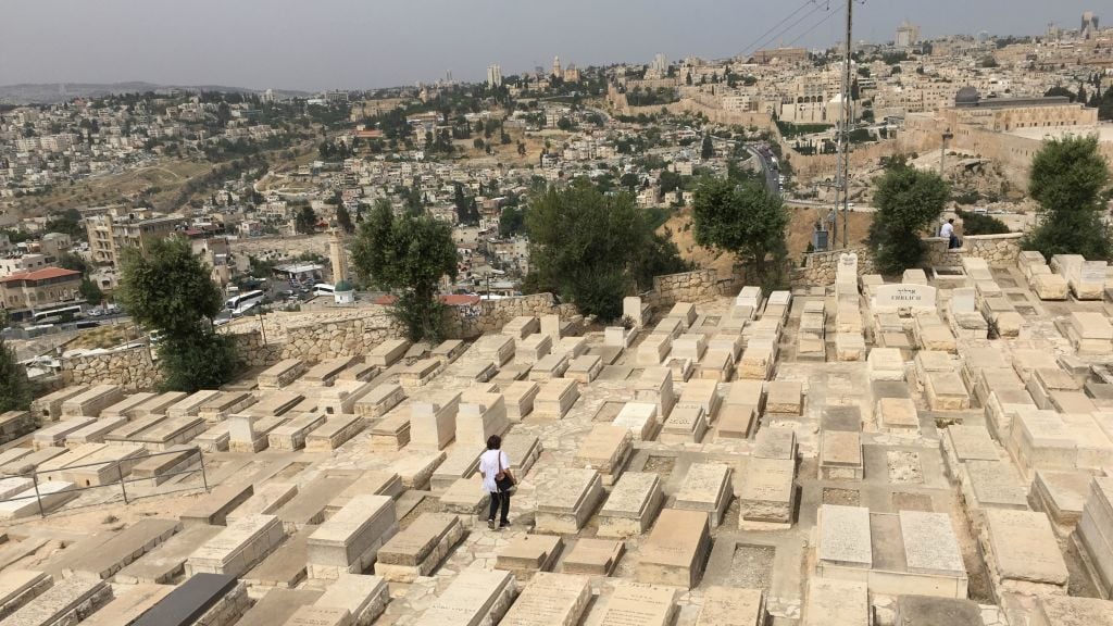 Rachel Barnea, one of the volunteers in Giving a Face to the Fallen, walks through one of the Mount of Olives burial plots on Israeli Memorial Day 2017 (Jessica Steinberg/Times of Israel)
