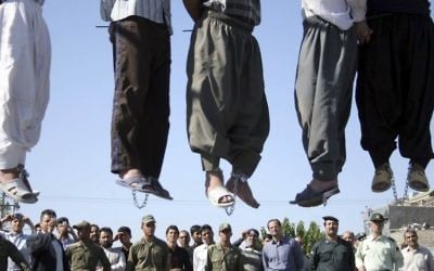 FILE -- In this Aug. 1, 2007, file photo, Iranian police officers and others view the scene as five convicted criminals are hanged in a neighborhood of Mashad, Iran. (AP/Halabisaz, File)
