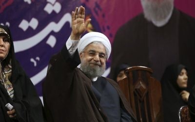 Iranian President Hassan Rouhani, center, waves to his supporters accompanied by Vice President for Women and Family Affairs Shahindokht Molaverdi, left, at a campaign rally for the May 19 presidential election, in Tehran, Iran, May 9, 2017. (AP/Vahid Salemi)