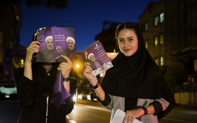 In this May 10, 2017 photo, supporters of Iranian President Hassan Rouhani hold his posters for May 19 presidential election in downtown Tehran, Iran. (AP Photo/Ebrahim Noroozi) In this May 10, 2017 photo, supporters of Iranian President Hassan Rouhani hold his posters for May 19 presidential election in downtown Tehran, Iran. (AP Photo/Ebrahim Noroozi)