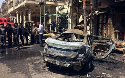 Iraqi security forces and civilians inspect the site of a deadly bomb attack, in Baghdad, Iraq, Monday, May 30, 2017. (AP Photo/Karim Kadim)