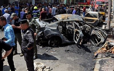 Iraqi security forces and civilians inspect the site of a deadly bomb attack, in Baghdad, Iraq, Monday, May 30, 2017. (AP Photo/Karim Kadim)
