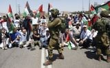 Protesters hold Palestinian flags in solidarity with Palestinian prisoners who are on a hunger strike in Israeli jails, near the West Bank city of Nablus, May 16, 2017. (AP/Majdi Mohammed)
