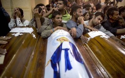 Relatives of Coptic Christians who were killed during a bus attack, surround their coffins, during their funeral service, at Abu Garnous Cathedral in Minya, Egypt, May 26, 2017. ﻿(AP Photo/Amr Nabil)