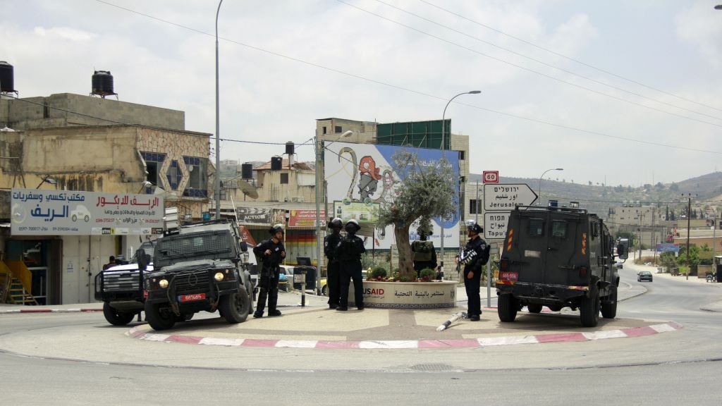 Israel Police officer guard a street where yesterday a group of Palestinians attacked an Israeli settler, who fired back, killing one person and wounding another, in Hawara, in the northern West Bank on May 19, 2017. (Judah Ari Gross/Times of Israel) Israel Police officer guard a street where yesterday a group of Palestinians attacked an Israeli settler, who fired back, killing one person and wounding another, in Hawara, in the northern West Bank on May 19, 2017. (Judah Ari Gross/Times of Israel)