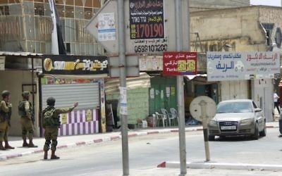 Israeli soldiers block the road from Hawara to Nablus, in the northern West Bank on May 19, 2017. (Judah Ari Gross/Times of Israel) Israeli soldiers block the road from Hawara to Nablus, in the northern West Bank on May 19, 2017. (Judah Ari Gross/Times of Israel)