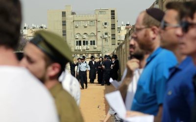Police keep a group of ultra-Orthodox protesters away from a ceremony for fallen ultra-Orthodox soldiers at a cemetery in the city of Bnei Brak on May 1, 2017, Israel's Memorial Day. (Judah Ari Gross/Times of Israel)