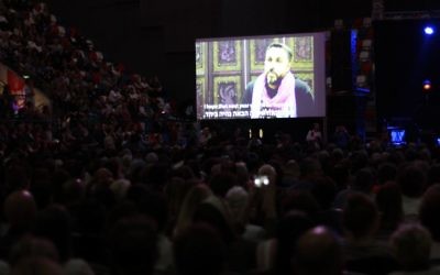 People watch Palestinians speak on pre-recorded videos after the Defense Ministry barred them from attending an Israeli-Palestinian memorial ceremony in Tel Aviv on April 30, 2017, as Israel marks its annual Memorial Day for fallen soldiers and victims of terror. (Tomer Neuberg/Flash90) People watch Palestinians speak on pre-recorded videos after the Defense Ministry barred them from attending an Israeli-Palestinian memorial ceremony in Tel Aviv on April 30, 2017, as Israel marks its annual Memorial Day for fallen soldiers and victims of terror. (Tomer Neuberg/Flash90)