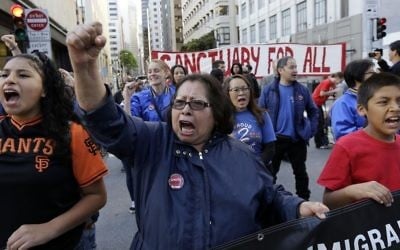 Guadalupe Chavez, center, and others yell during a protest outside of the U.S. Citizen and Immigration Services building in San Francisco, Monday, May 1, 2017. (AP/Jeff Chiu)