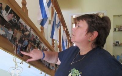 Natasha Kryzhanovsky, a Christians for Israel fieldworker, looks at photographs of Ukrainian Jews who have passed through the organization's shelter on their way to Israel, May 4, 2017, Ukraine. (Sue Surkes)