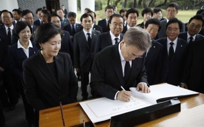 New South Korea's President Moon Jae-in, center, writes down a visitor's book at the National Cemetery in Seoul, South Korea Wednesday, May 10, 2017. (Kim Hong-ji/AP)