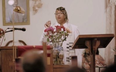 A woman delivering a sermon while draped in a tallit from the documentary '4 Your Eyez Only,' by rapper J. Cole. (Youtube/Dreamville)