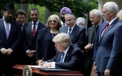 US President Donald Trump signs an executive order in the Rose Garden of the of the White House in Washington, Thursday, May 4, 2017, asking the IRS to use "maximum enforcement discretion" over the regulation, known as the Johnson Amendment, which applies to churches and nonprofits (AP Photo/Evan Vucci)