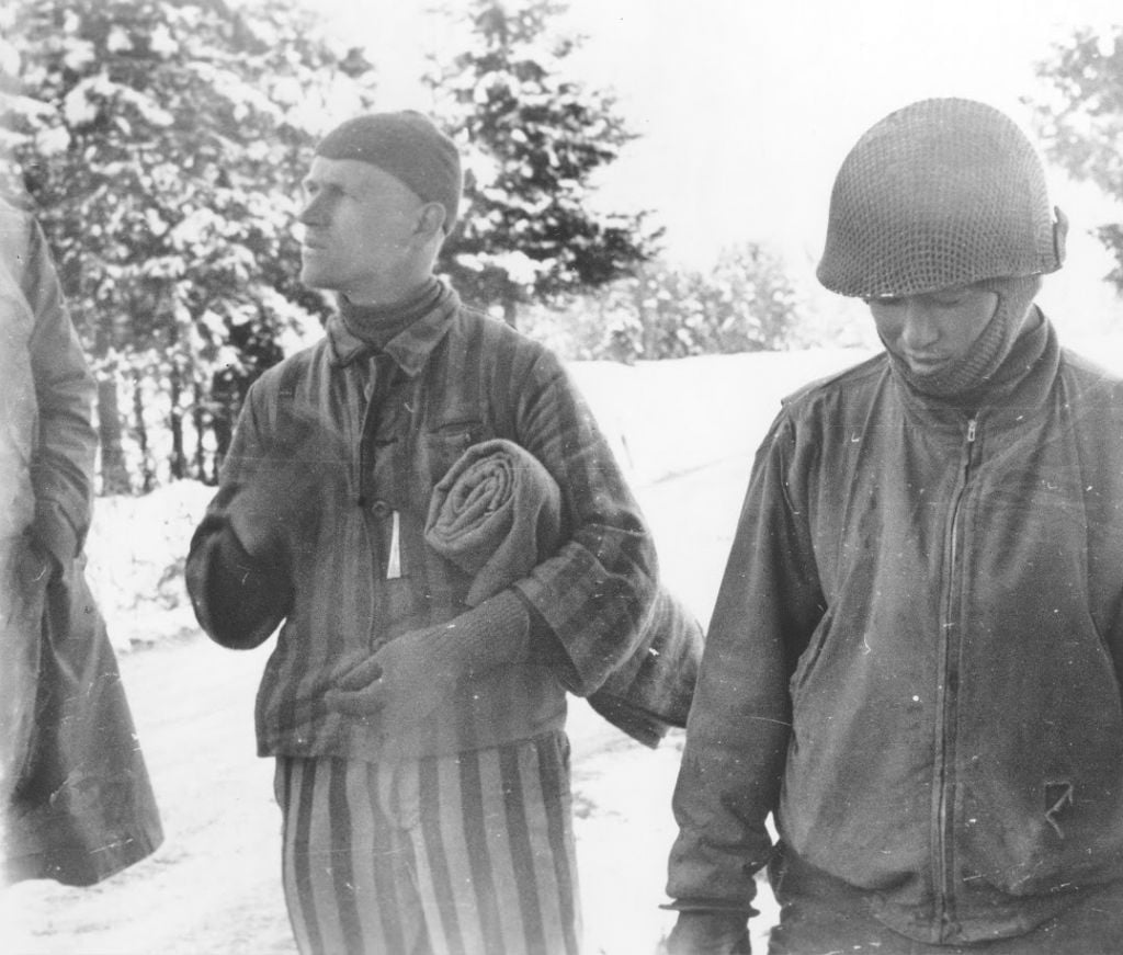 Tahae Sugita (right), a Japanese-American soldier with the 522nd Field Artillery battalion, stands next to a concentration camp survivor he has just liberated on a death march from Dachau. (Courtesy USHMM/Eric Saul) Tahae Sugita (right), a Japanese-American soldier with the 522nd Field Artillery battalion, stands next to a concentration camp survivor he has just liberated on a death march from Dachau. (Courtesy USHMM/Eric Saul)
