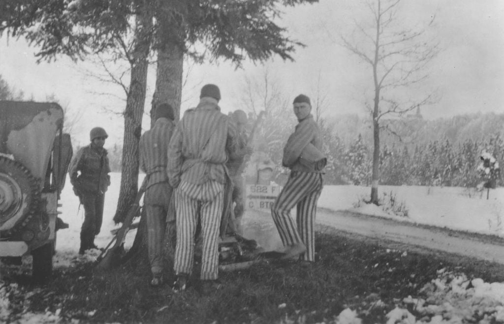 Survivors from a death march from Dachau huddle around a campfire prepared by Japanese-American soldiers with the 522nd Field Artillery Battalion. The soldier on the left is George Oiye. (Courtesy USHMM/Eric Saul) Survivors from a death march from Dachau huddle around a campfire prepared by Japanese-American soldiers with the 522nd Field Artillery Battalion. The soldier on the left is George Oiye. (Courtesy USHMM/Eric Saul)