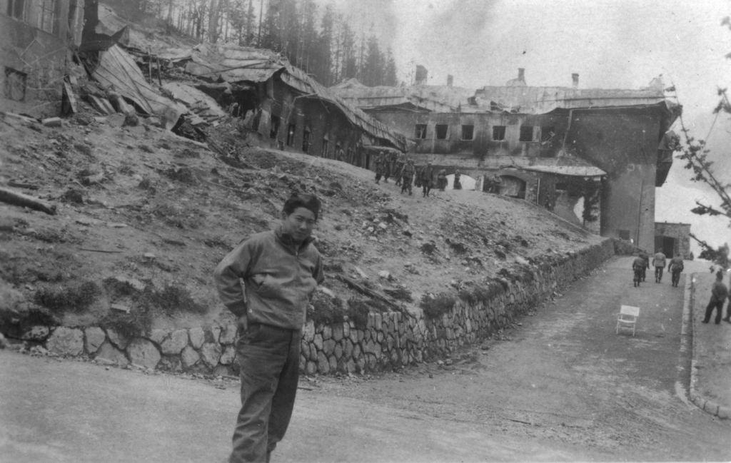 A Japanese-American soldier poses outside the destroyed Berghof, Hitler's mountain retreat in the Bavarian Alps. (Courtesy USHMM/Eric Saul) A Japanese-American soldier poses outside the destroyed Berghof, Hitler's mountain retreat in the Bavarian Alps. (Courtesy USHMM/Eric Saul)