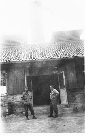Two Japanese-American soldiers with the 522nd Field Artillery Battalion stand in front of the crematorium in the Dachau concentration camp soon after the liberation. (Courtesy USHMM/Eric Saul) Two Japanese-American soldiers with the 522nd Field Artillery Battalion stand in front of the crematorium in the Dachau concentration camp soon after the liberation. (Courtesy USHMM/Eric Saul)