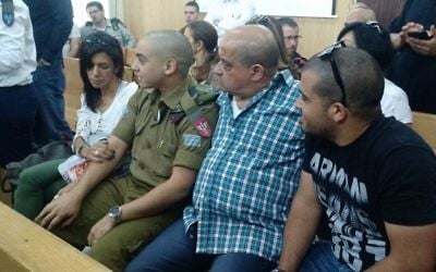IDF soldier Elor Azaria sits between his parents in a courtroom at the Kirya military headquarters in Tel Aviv for an appeal hearing on Wednesday, May 3, 2017 (Judah Ari Gross/Times of Israel)