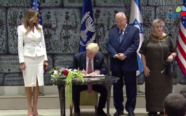 US President Donald Trump signs the guestbook at the official residence of his Israeli counterpart, Reuven Rivlin, who watches on, on Monday, May 22, 2017 (screen capture: GPO)