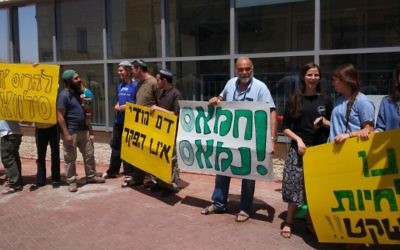 Demonstrators hold signs outside the Binyamin police station in the West Bank in support of two Israeli settlers who were detained for involvement in the shooting of Palestinian stone throwers. (Courtesy
